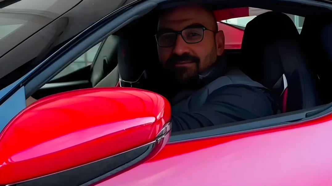 Inhaber von Veluxio im roten Ferrari